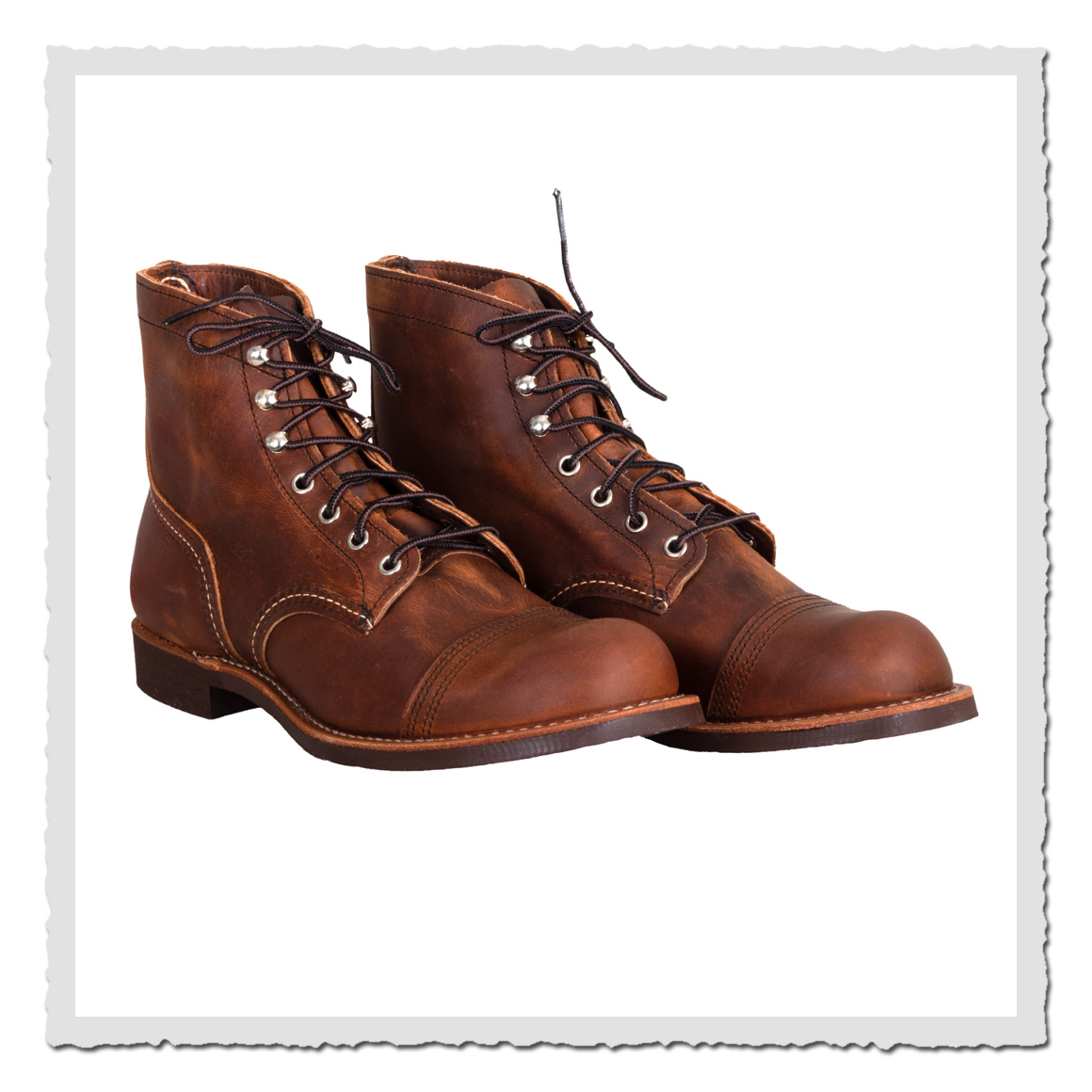 Braune Lederstiefel frontal leicht schräg, schwarze Schnürsenkel und weißer Hintergrund.